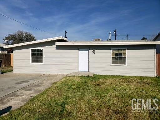 back of house with a lawn and a patio area