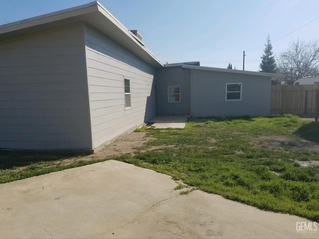 view of property exterior featuring a patio area and a yard