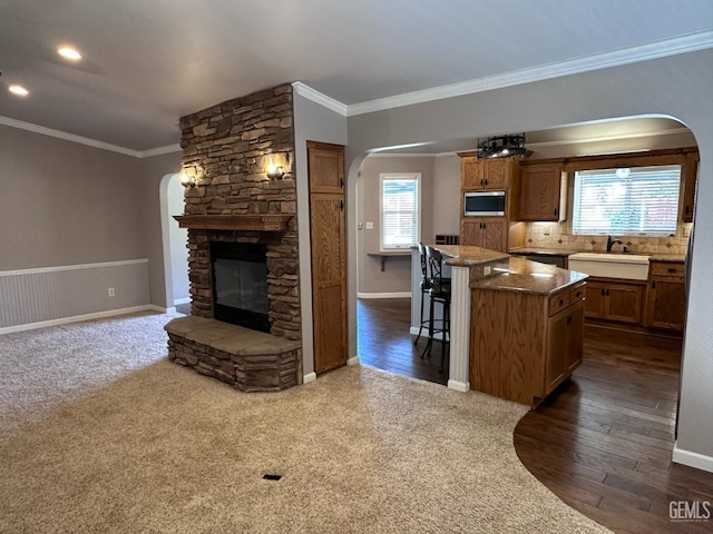 4049 Liz Dr, Bakersfield, CA 93312 - kitchen with arched walkways, stainless steel microwave, plenty of natural light, ornamental molding, and recessed lighting