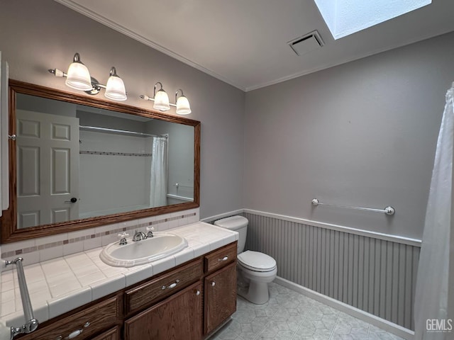 4049 Liz Dr, Bakersfield, CA 93312 - full bathroom featuring wainscoting, vanity, a skylight, crown molding, and curtained shower