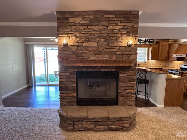 4049 Liz Dr, Bakersfield, CA 93312 - detailed view of crown molding, a stone fireplace, custom range hood, stainless steel range with gas cooktop, and carpet