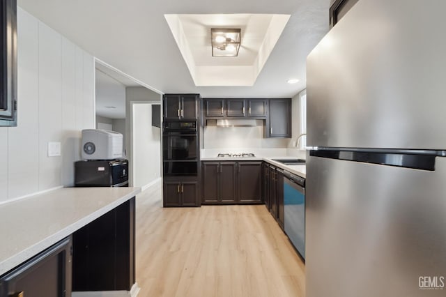 4401 Hughes Ln Unit 148, Bakersfield, CA 93304 - kitchen featuring stainless steel appliances, a warming drawer, light wood-style flooring, a tray ceiling, and light countertops