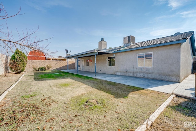 back of house with a lawn and a patio