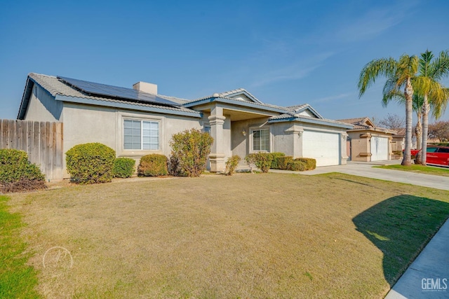 view of front facade featuring a garage, a front yard, and solar panels