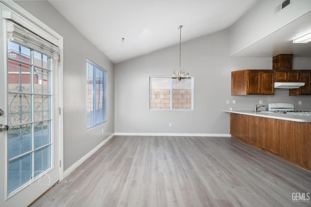 kitchen featuring vaulted ceiling, decorative light fixtures, light hardwood / wood-style floors, white range oven, and an inviting chandelier