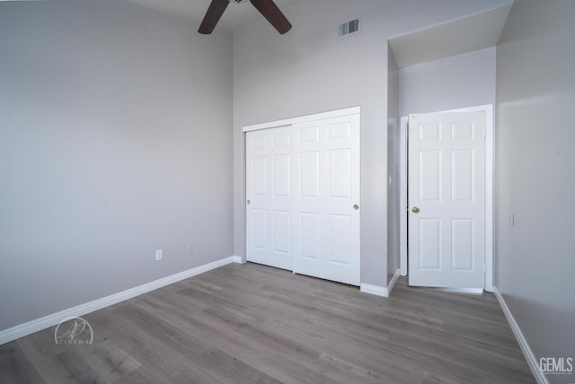 unfurnished bedroom featuring ceiling fan, hardwood / wood-style flooring, and a closet