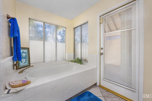 bathroom with tile patterned flooring and tiled bath