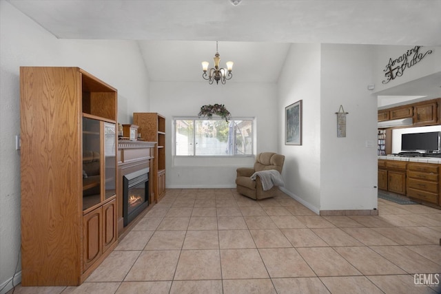 living area with lofted ceiling, light tile patterned floors, and an inviting chandelier