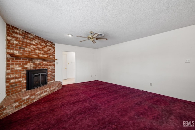 unfurnished living room with carpet flooring, a textured ceiling, a fireplace, and a ceiling fan