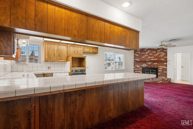 kitchen featuring wall oven, plenty of natural light, a brick fireplace, and open floor plan