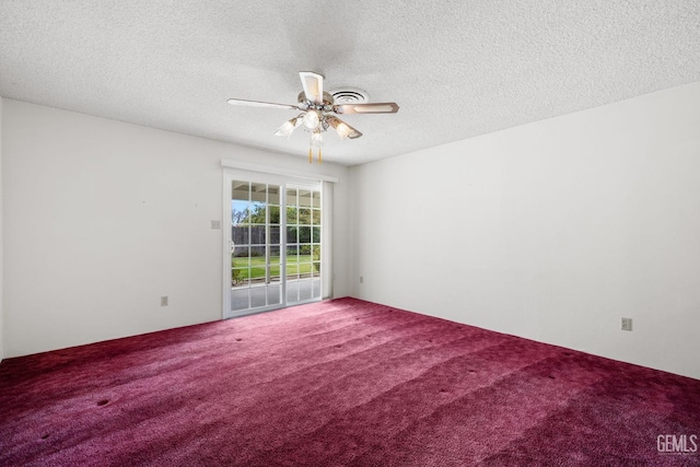 carpeted spare room featuring a textured ceiling and ceiling fan