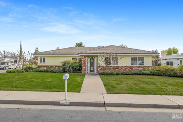 view of front of home featuring a front lawn and brick siding