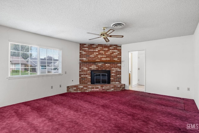 unfurnished living room with visible vents, carpet, a fireplace, and a ceiling fan