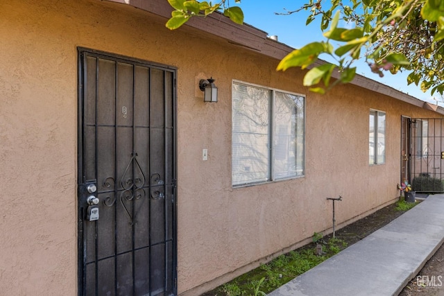 view of exterior entry with stucco siding