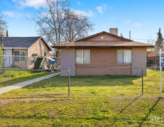 view of side of home featuring stucco siding, a yard, and fence