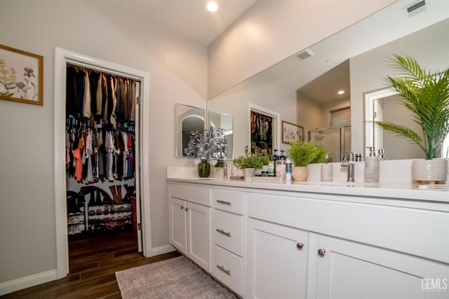 8414 Kowa St, Bakersfield, CA 93314 - bathroom with double vanity, wood finished floors, a shower stall, a walk in closet, and recessed lighting