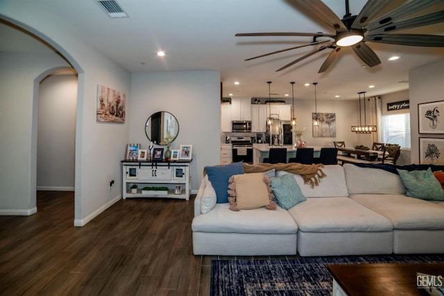 8414 Kowa St, Bakersfield, CA 93314 - living room featuring ceiling fan, arched walkways, dark wood-style flooring, recessed lighting, and a chandelier