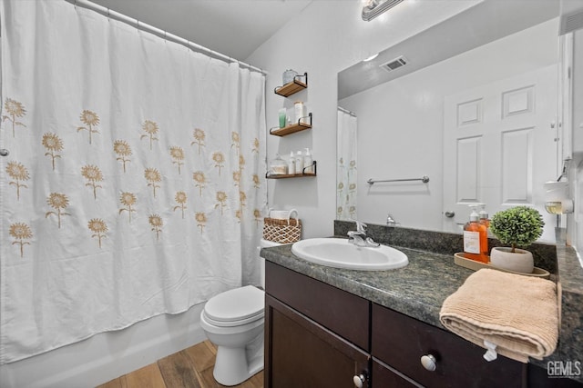 full bathroom featuring hardwood / wood-style flooring, vanity, toilet, and shower / bath combo with shower curtain