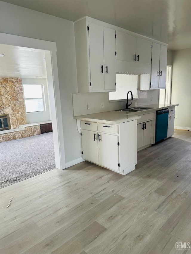 kitchen with dishwasher, white cabinets, and sink