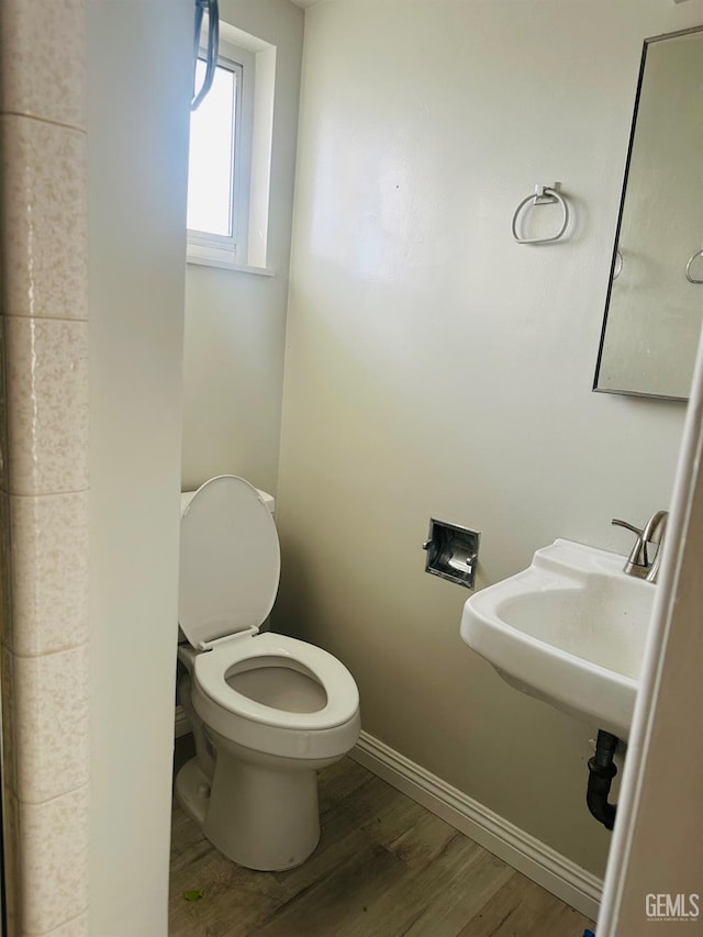 bathroom with hardwood / wood-style floors, toilet, and sink