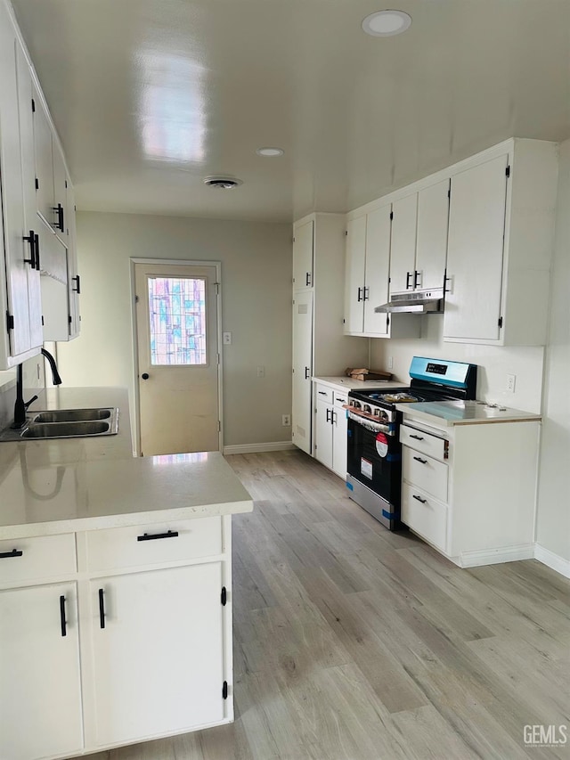 kitchen with white cabinets, light hardwood / wood-style floors, stainless steel range with gas cooktop, and sink