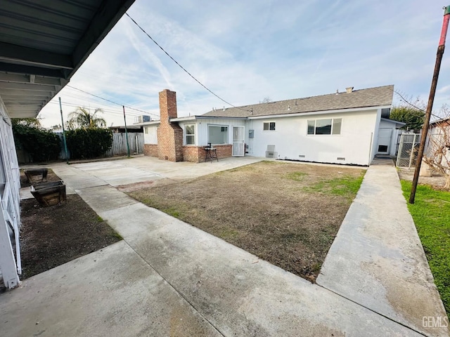 rear view of house with central AC unit, a patio area, and a lawn