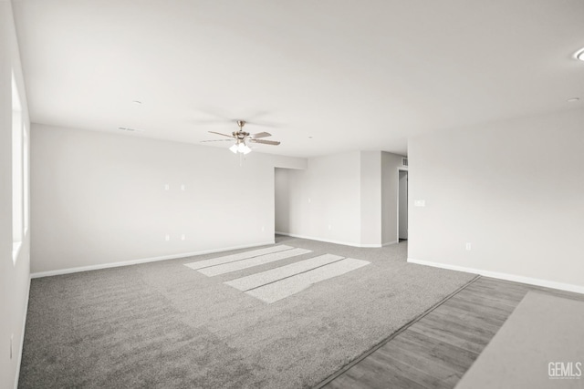 unfurnished room featuring ceiling fan, visible vents, wood finished floors, baseboards, and carpet