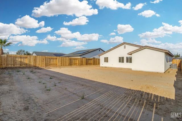 rear view of property with a fenced backyard, stucco siding, and cooling unit