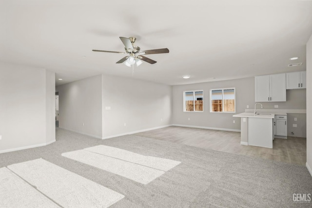 unfurnished living room featuring baseboards, a ceiling fan, recessed lighting, and light colored carpet