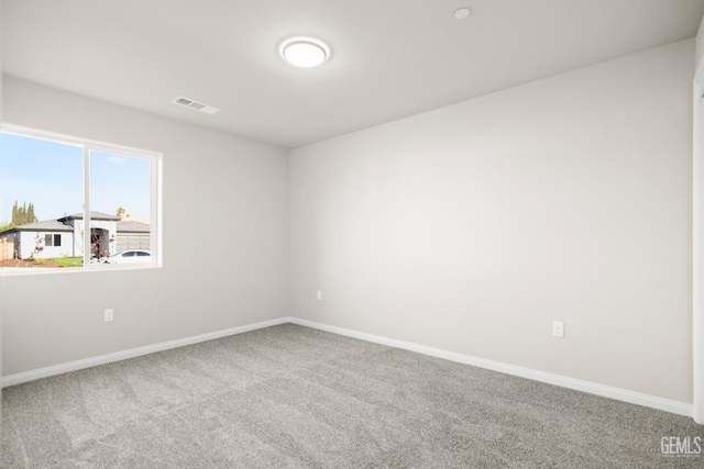 unfurnished room with visible vents, baseboards, and carpet floors