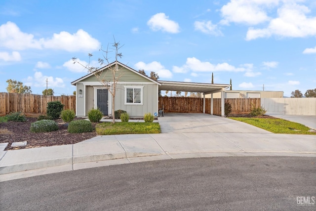 view of front facade with fence private yard, an attached carport, board and batten siding, and concrete driveway