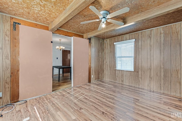 unfurnished room featuring beam ceiling, hardwood / wood-style flooring, and ceiling fan with notable chandelier