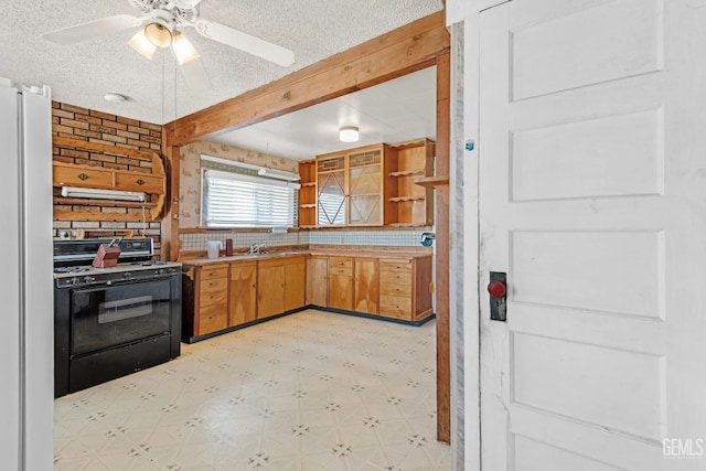 kitchen featuring refrigerator, a textured ceiling, black range with gas stovetop, ceiling fan, and exhaust hood