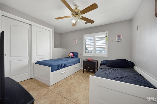 bedroom with light tile patterned floors, a ceiling fan, and a closet