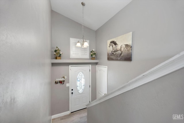 entrance foyer featuring stairs, an inviting chandelier, baseboards, and lofted ceiling