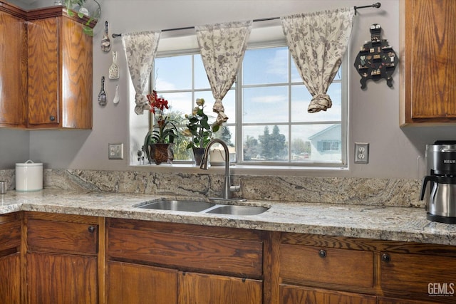 kitchen featuring a sink, brown cabinets, and a healthy amount of sunlight