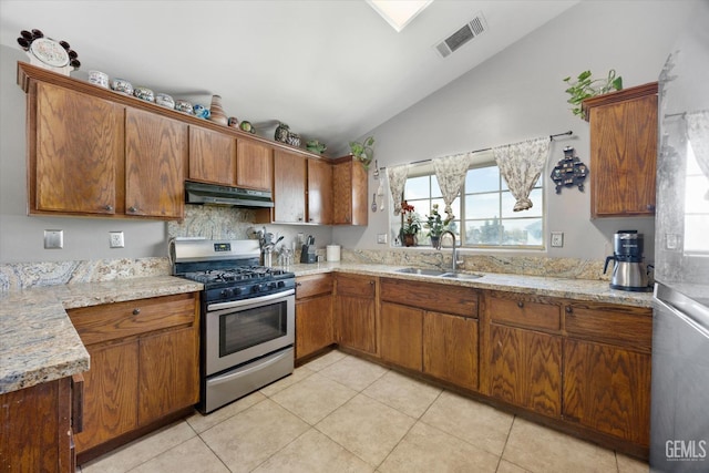 kitchen with a healthy amount of sunlight, visible vents, a sink, under cabinet range hood, and gas range