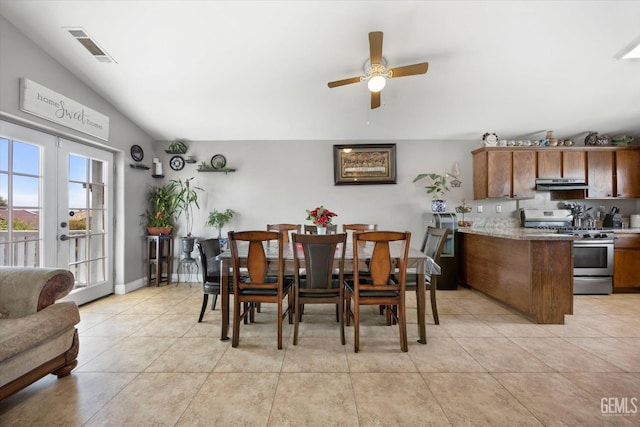 dining space with light tile patterned flooring, visible vents, french doors, and lofted ceiling