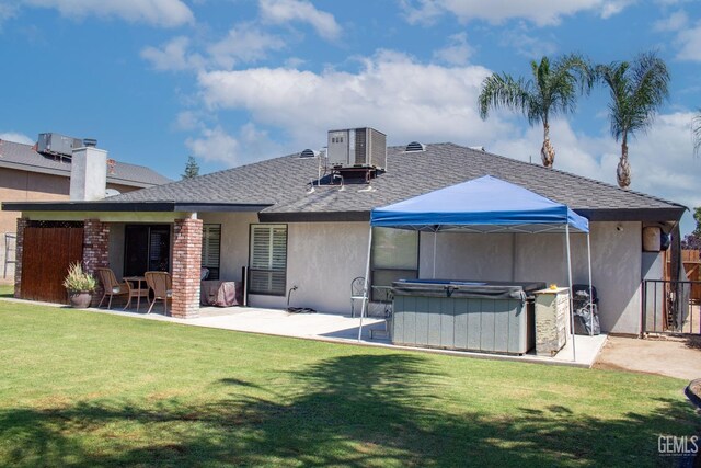 1301 Charterten Ave, Bakersfield, CA 93307 - back of property featuring a hot tub, a patio, roof with shingles, cooling unit, and stucco siding