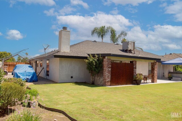 1301 Charterten Ave, Bakersfield, CA 93307 - rear view of house with a chimney, a patio area, roof with shingles, and central AC unit