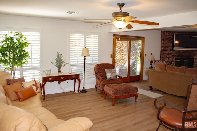 1301 Charterten Ave, Bakersfield, CA 93307 - living area featuring a ceiling fan, light wood finished floors, healthy amount of natural light, and a brick fireplace