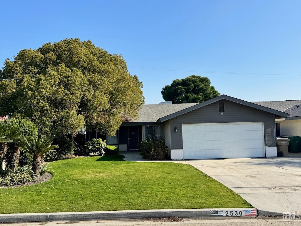 view of front of house featuring a front lawn and a garage