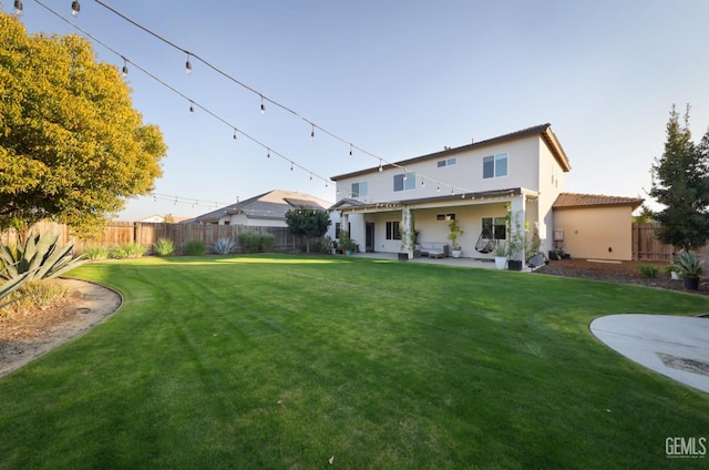 back of property featuring a lawn and a patio area