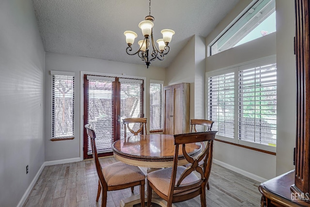 9604 Lea Oak Rd, Bakersfield, CA 93311 - dining room featuring a chandelier, light wood-style flooring, vaulted ceiling, and a textured ceiling