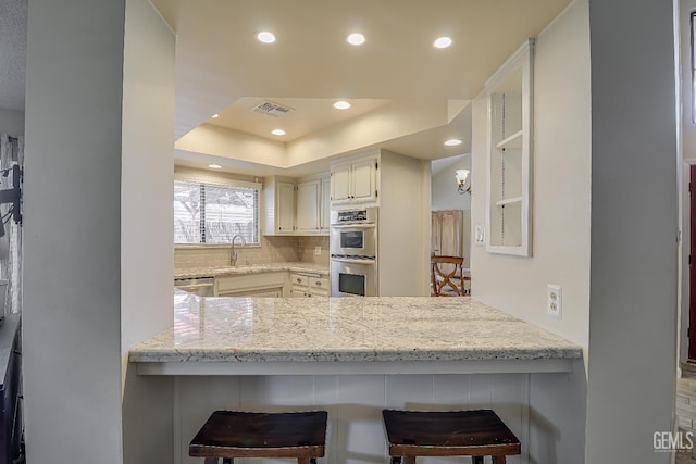 9604 Lea Oak Rd, Bakersfield, CA 93311 - kitchen featuring stainless steel appliances, recessed lighting, a peninsula, backsplash, and light stone counters