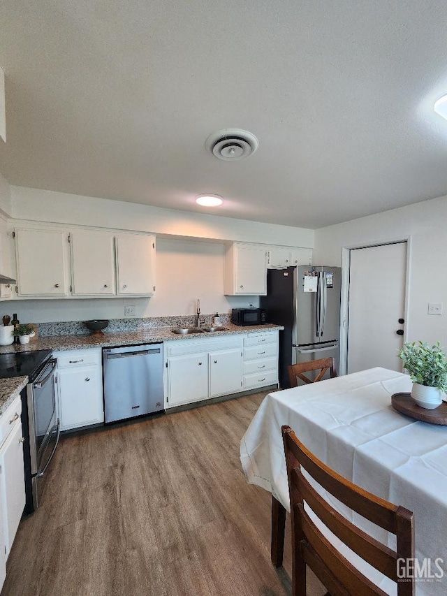 5812 Appletree Ln, Bakersfield, CA 93309 - kitchen featuring stainless steel appliances, wood finished floors, and white cabinets
