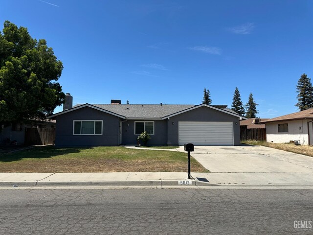 single story home with concrete driveway, fence, a garage, a front yard, and stucco siding