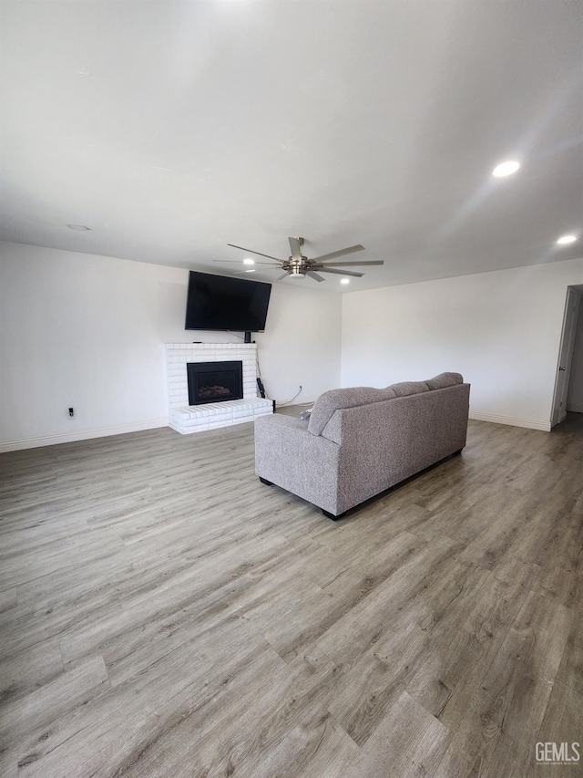 5812 Appletree Ln, Bakersfield, CA 93309 - living area with wood finished floors, a brick fireplace, baseboards, ceiling fan, and recessed lighting