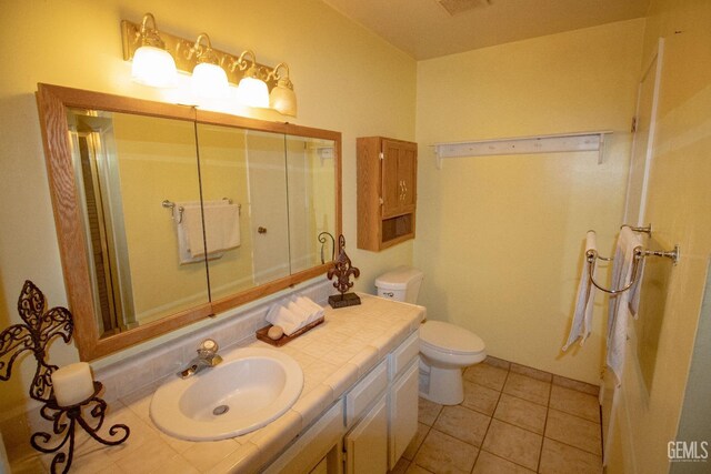 bathroom with a ceiling fan, vanity, toilet, and tile patterned floors