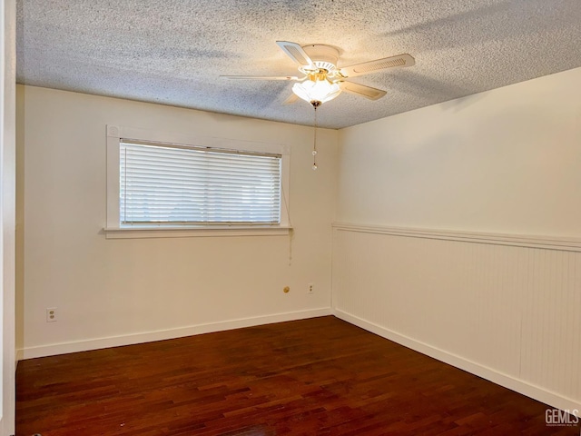 empty room featuring ceiling fan, a textured ceiling, baseboards, and wood finished floors